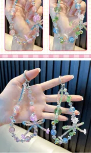 Detailed view of colorful beaded phone straps with floral and bow charms for women.