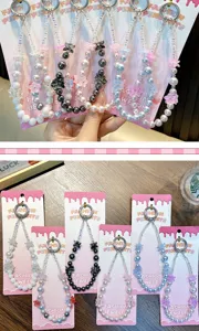 Detail view of handmade beaded flower phone charms in various colors on pink cards.