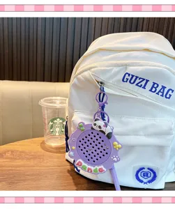 Vista dettagliata di un portachiavi a forma di panda viola appeso a uno zaino bianco