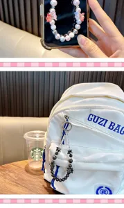 Detail showing a beaded flower phone chain as a decorative charm on a white backpack