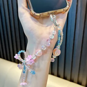 Elegant handmade beaded phone strap featuring pink flowers and blue crystal bow pendant