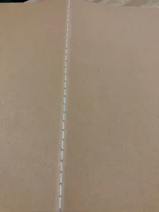 Detailopname van witte gestikte binding op een vintage kraftpapier notitieboek kaft.