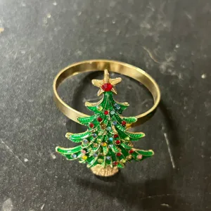 Vista detallada del adorno de árbol de Navidad verde en un servilletero dorado