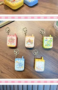 Set of five colorful mini phone-shaped electronic maze game keychains on a wooden desk