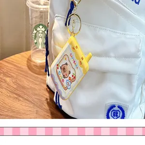 Close-up of a cute yellow Capybara mini phone puzzle toy keychain hanging on a white backpack