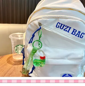 Close-up of popsicle liquid keychain with watermelon inside on a white backpack