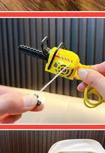 Detailed shot of hand pulling the string of a miniature yellow chainsaw keychain toy.