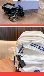 Detailed view of a vintage tricycle model keychain hanging on a white canvas backpack.