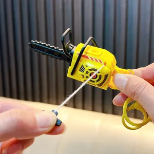 Mini pull-string vibrating chainsaw keychain toy in yellow and black shown held in hand