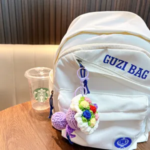 Portachiavi a bouquet di fiori colorati fatto a mano appeso a uno zaino bianco, regalo.