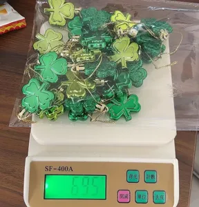 Set of 24 St. Patrick's Day shamrock ornaments weighed at 69.5 grams on a digital scale.