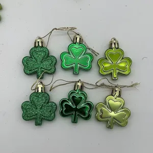Detailed view of green shamrock hanging ornaments with glitter and glossy finishes for party