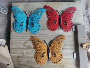 Detailed view of three vibrant hollow iron butterfly wall ornaments for home decor.