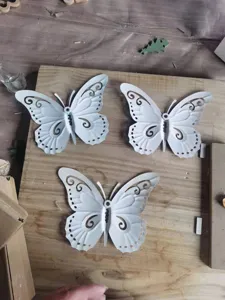 Close-up detail of three white 3D hollow iron butterflies for home wall decoration