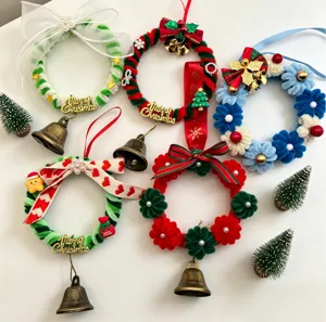 Detailed view of DIY Christmas pipe cleaner wreaths with bells and bows