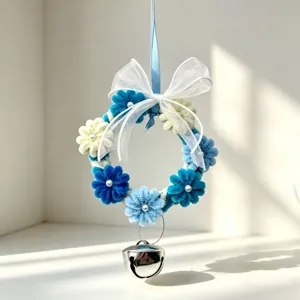 Close-up view of blue and white DIY pipe cleaner wreath with silver bell and ribbon.