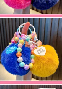 Detailed macro view of colorful beaded faux fur pom-pom keychain charms