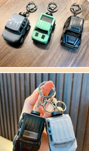 Close-up of mini alloy off-road vehicle keychains in grey and black finishes