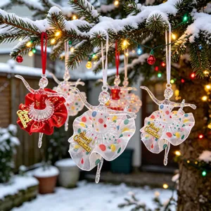 Detailed view of acrylic ballerina ornaments with colorful skirts on a snowy Christmas tree.
