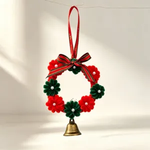 Close-up detail of a handmade Christmas pipe cleaner flower wreath with golden bell ornament