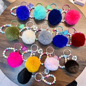 Collection of colorful faux fur pom-pom keychains with beaded wrist straps and heart charms