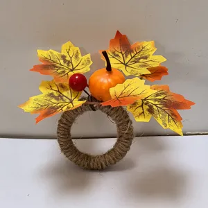 Close-up of rustic Thanksgiving napkin ring featuring mini pumpkin and maple leaves