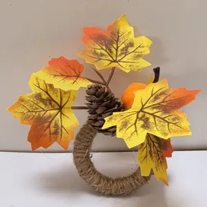 Detailed view of handmade twine napkin ring with artificial maple leaves and pinecone