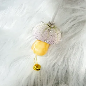 Detailed shot of mushroom ornament made from sea urchin shells with pearls and bell