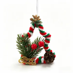 Close-up of handmade Christmas tree ornament with pine needles and festive red berries
