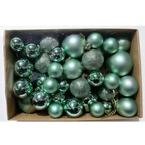 Detailed view of 50pcs mint green Christmas balls in a kraft box with mixed textures.