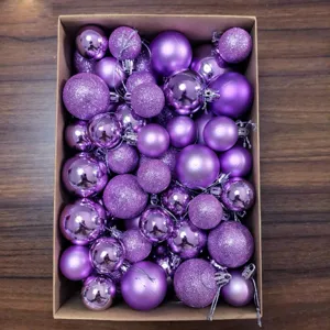 Close-up view of assorted purple Christmas baubles with matte and glitter finishes in a box