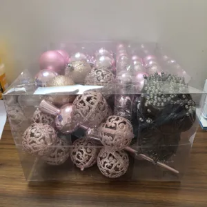 Detailed close-up of a Christmas ornament gift box featuring pink balls and LED light string