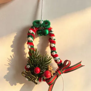 Handmade Christmas bell ornament made from red and green pipe cleaners with festive decor