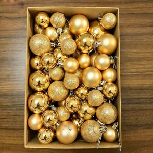 Overhead view of various gold Christmas ball ornaments in a kraft paper gift box