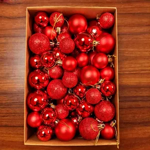 Top view of red Christmas baubles set in a box with shiny, matte, and glitter finishes.
