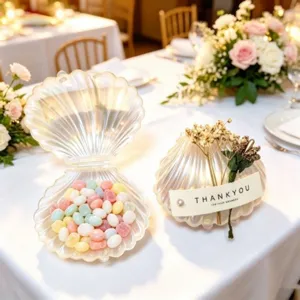 Elegante scatola di caramelle nuziali a forma di conchiglia perlata su un tavolo