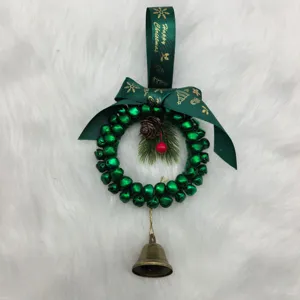 Close-up detail of a handmade green bell Christmas wreath with ribbon and pinecone