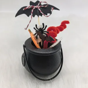 Halloween witch cauldron cake topper set with bat, spider, and pumpkin decorations.