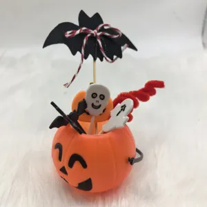 Detailed view of Halloween pumpkin bucket featuring ghost, skull, and bat decorative cake toppers