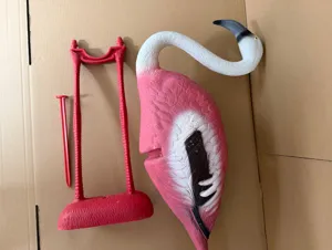 Detailed view of disassembled plastic garden flamingo decoration with ground stake