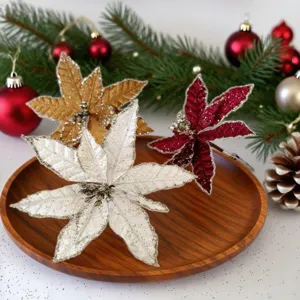 Close-up of gold, white and red glittery Christmas poinsettia flowers on wooden plate