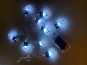 Halloween decorative LED string lights with glowing white skull heads and battery pack