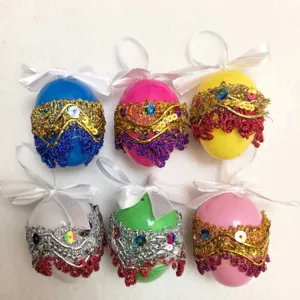 Detailed view of six colorful DIY Easter eggs with sequins and lace decorations