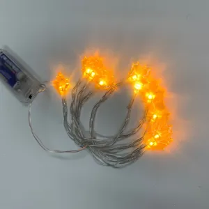 Close-up of glowing orange maple leaf LED string lights with battery box for Halloween