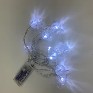 Detail view of fish-shaped LED string lights with battery box emitting cool white light