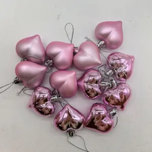 Detail of 12 pink heart-shaped hanging ornaments in mixed matte and shiny finishes