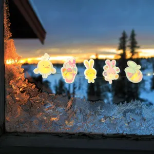 Pegatinas luminosas de Pascua para ventanas con conejos y huevos frente al atardecer