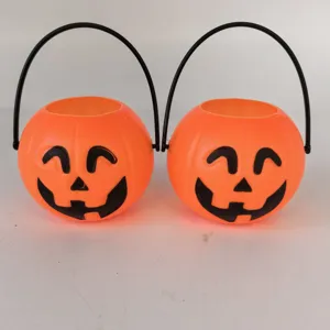 Close-up of two classic orange Jack-o'-lantern pumpkin candy buckets with black handles