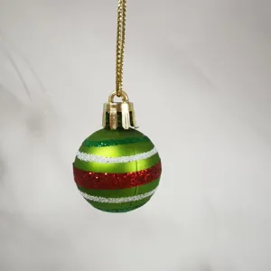 Detailed macro view of a 3cm mini green Christmas ball with glitter stripes for tree decor.