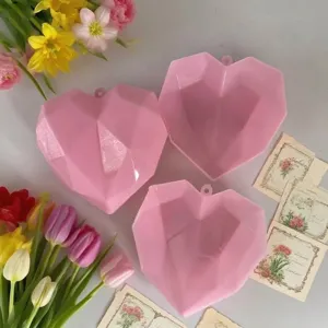 Tres cajas de regalo con forma de corazón rosa facetado y adornos para la fiesta de San Valentín